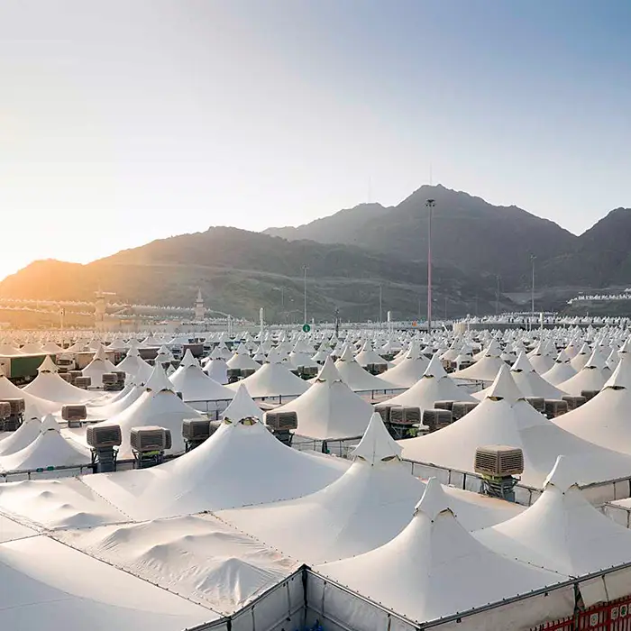 The tent city at Mina at first light, rank after rank of white peaked canopies with their air-conditioning units between them, running back to the bare mountains behind.